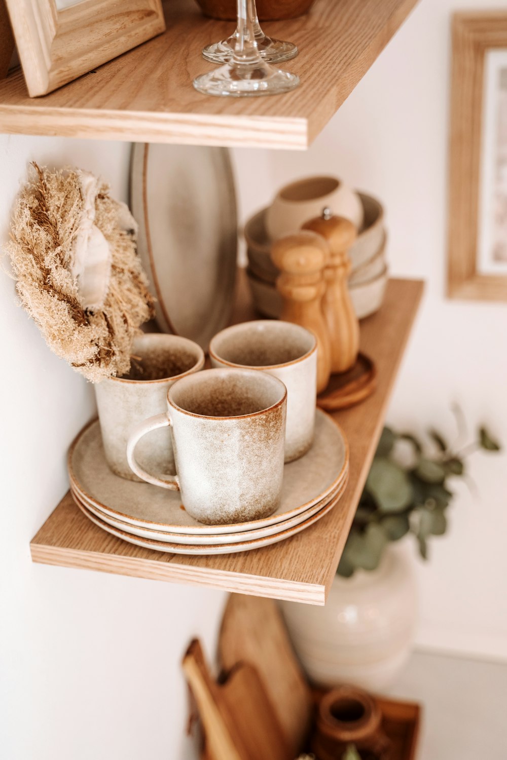 a couple of cups sitting on top of a wooden shelf