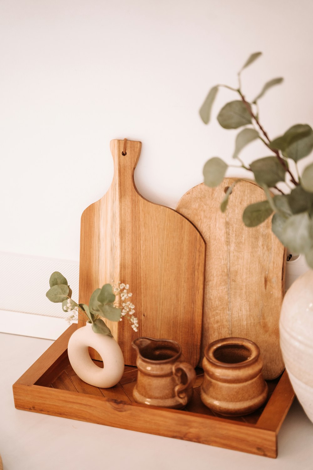 a wooden tray with a cutting board and two mugs