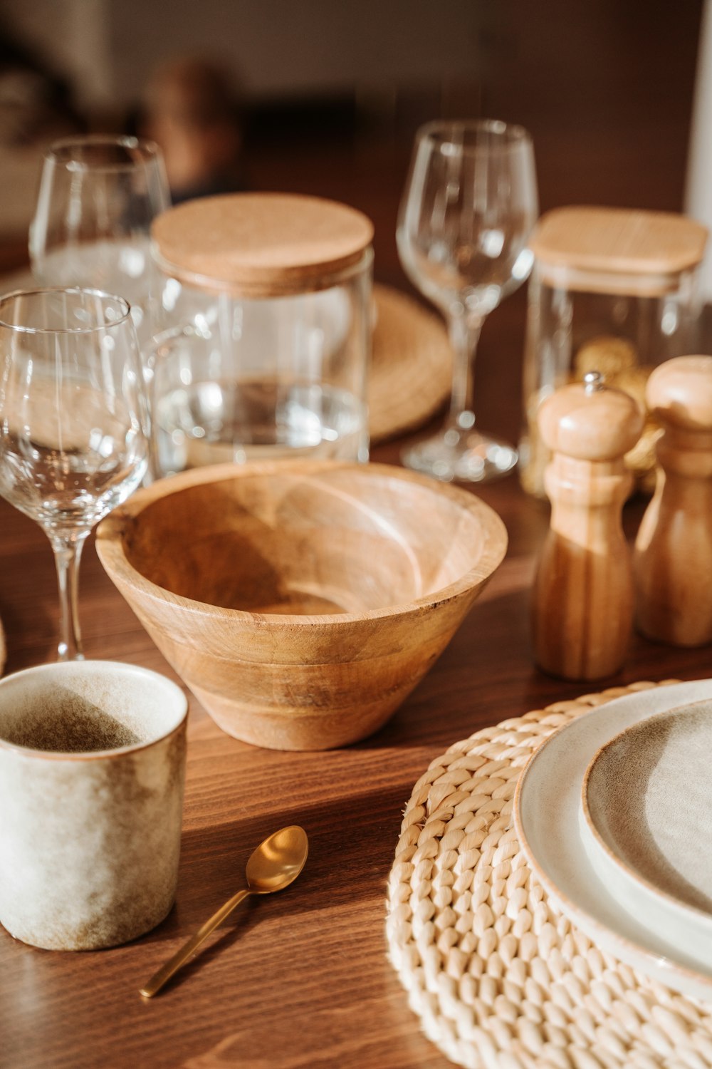 a wooden table topped with plates and bowls