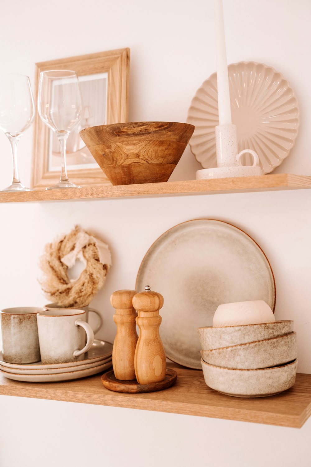 a shelf filled with dishes and plates on top of a wooden shelf