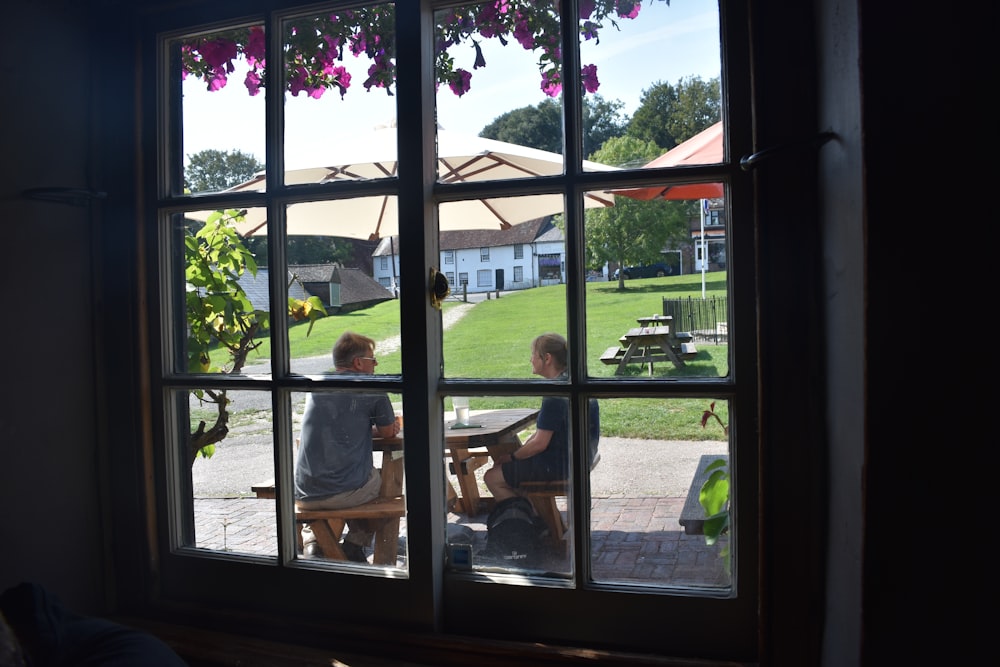 a couple of people sitting at a table in front of a window