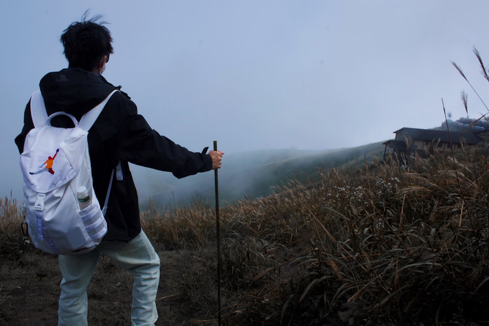 a person with a backpack and a stick on a hill