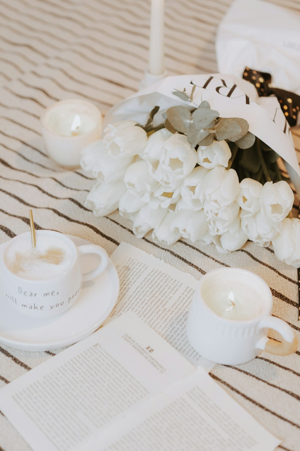 a table topped with white flowers and candles