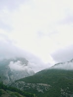 A peaceful mountain landscape with mist rolling over the peaks.