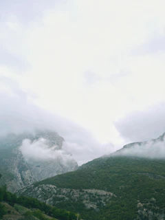 A scenic shot of a serene mountain landscape near Zhangjiajie with mist rolling over the peaks.