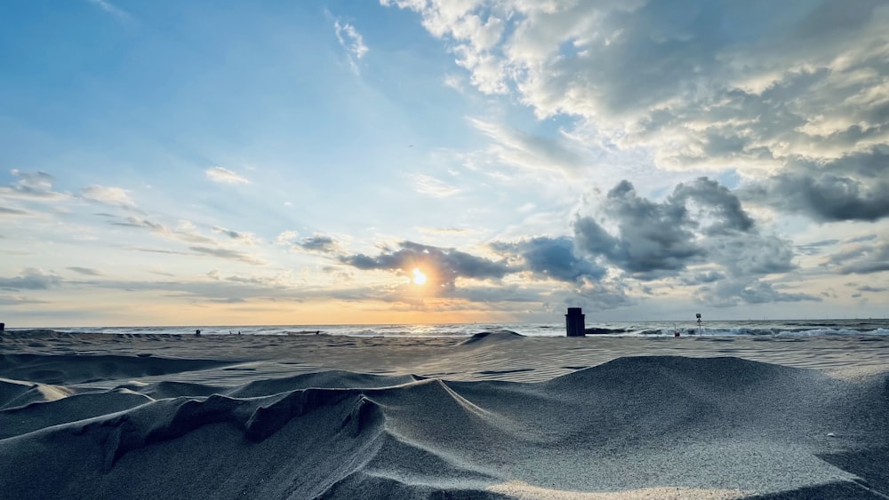 Le soleil se couche sur l’océan et les dunes de sable