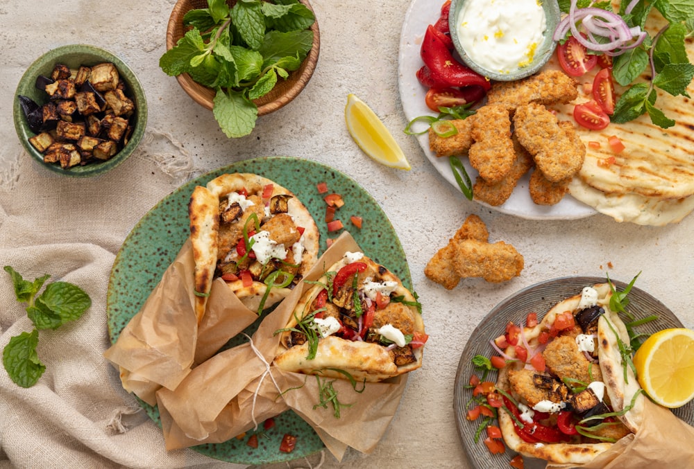 a table topped with plates of food and a bowl of salad