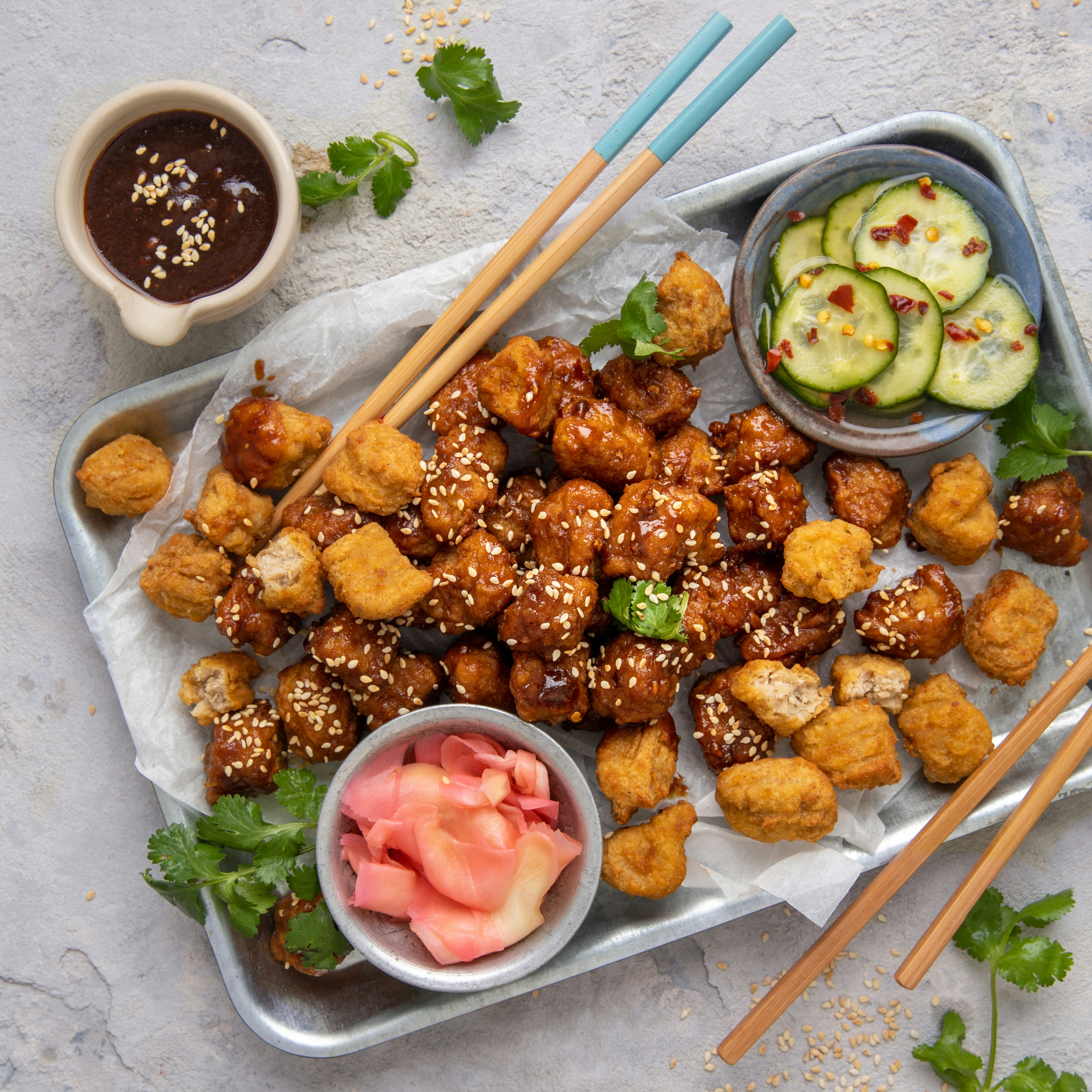 a tray of food with chopsticks and dipping sauce