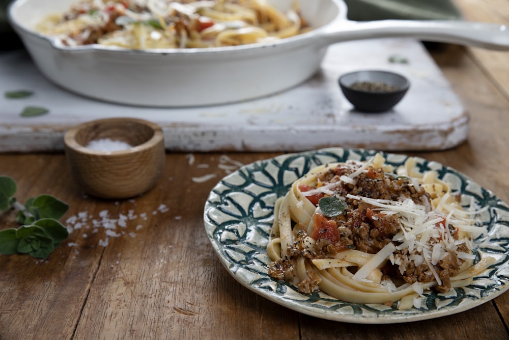 a plate of pasta with meat sauce and parmesan cheese