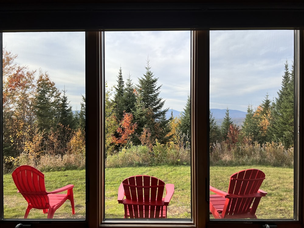 a couple of red chairs sitting in front of a window