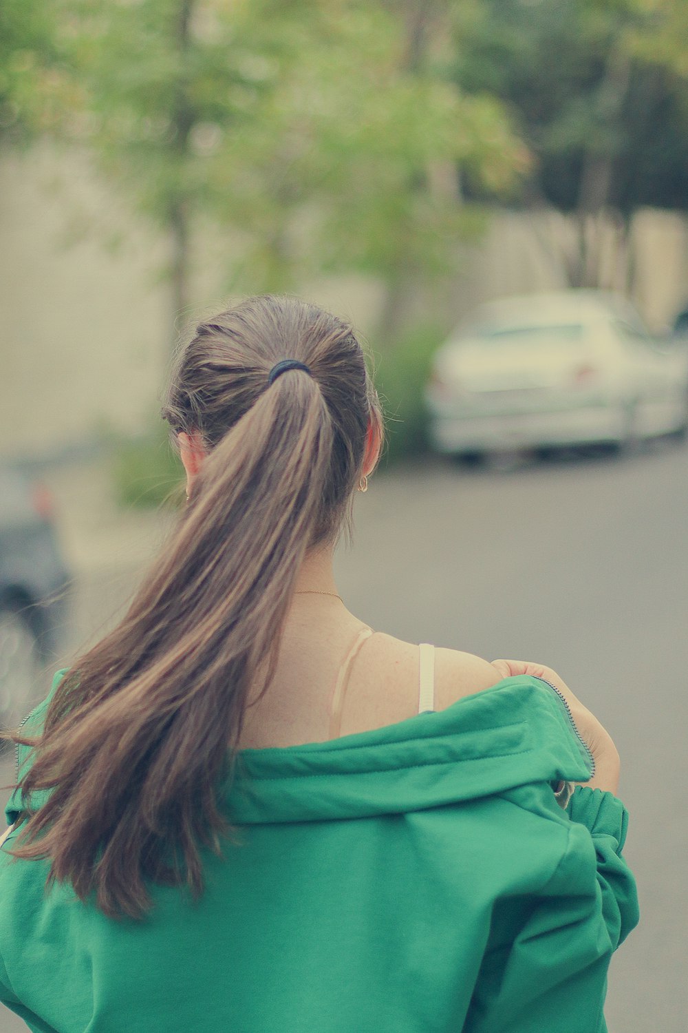 a woman in a green top walking down a street