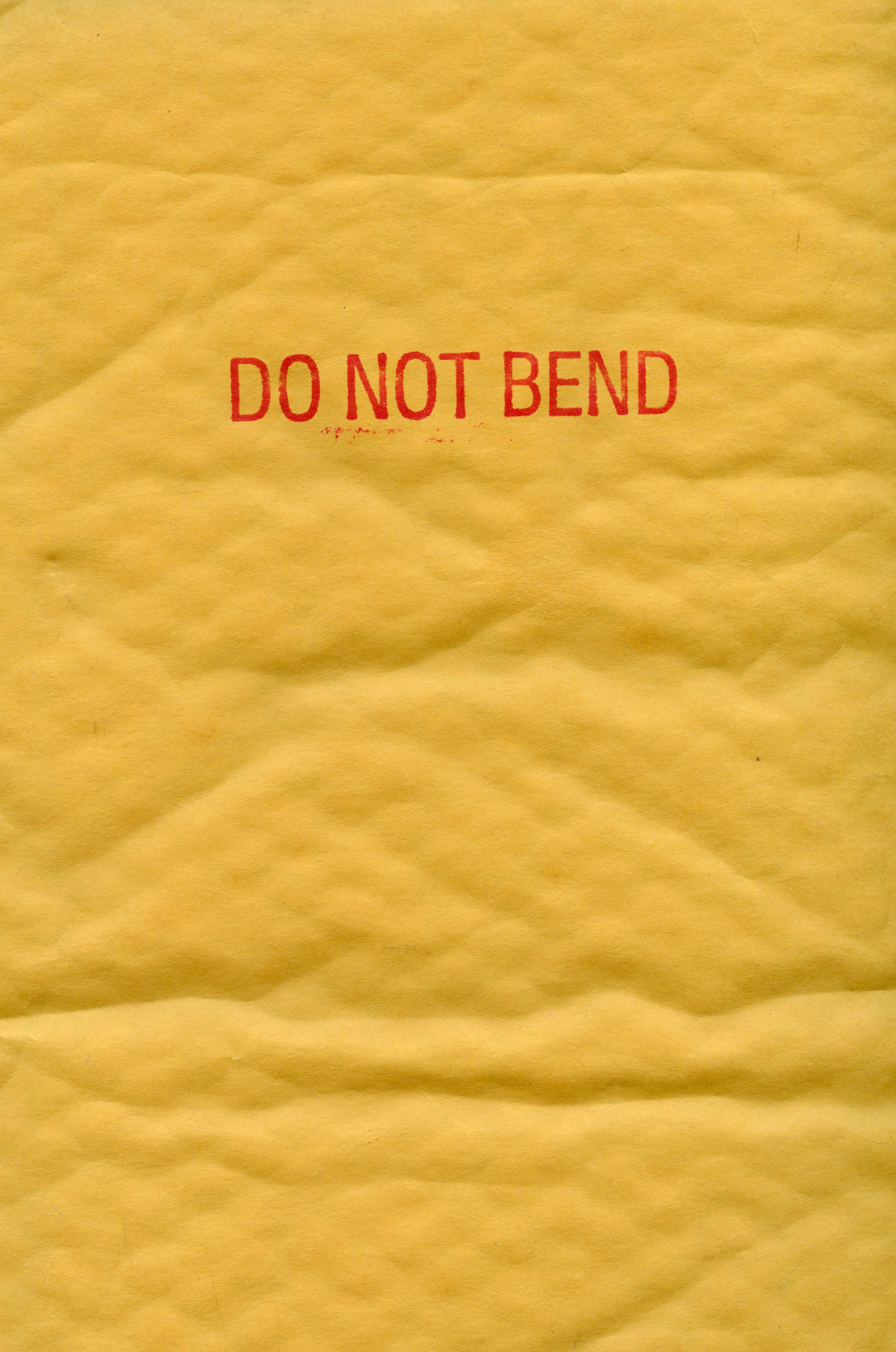 a piece of yellow paper with a red do not bend sign on it
