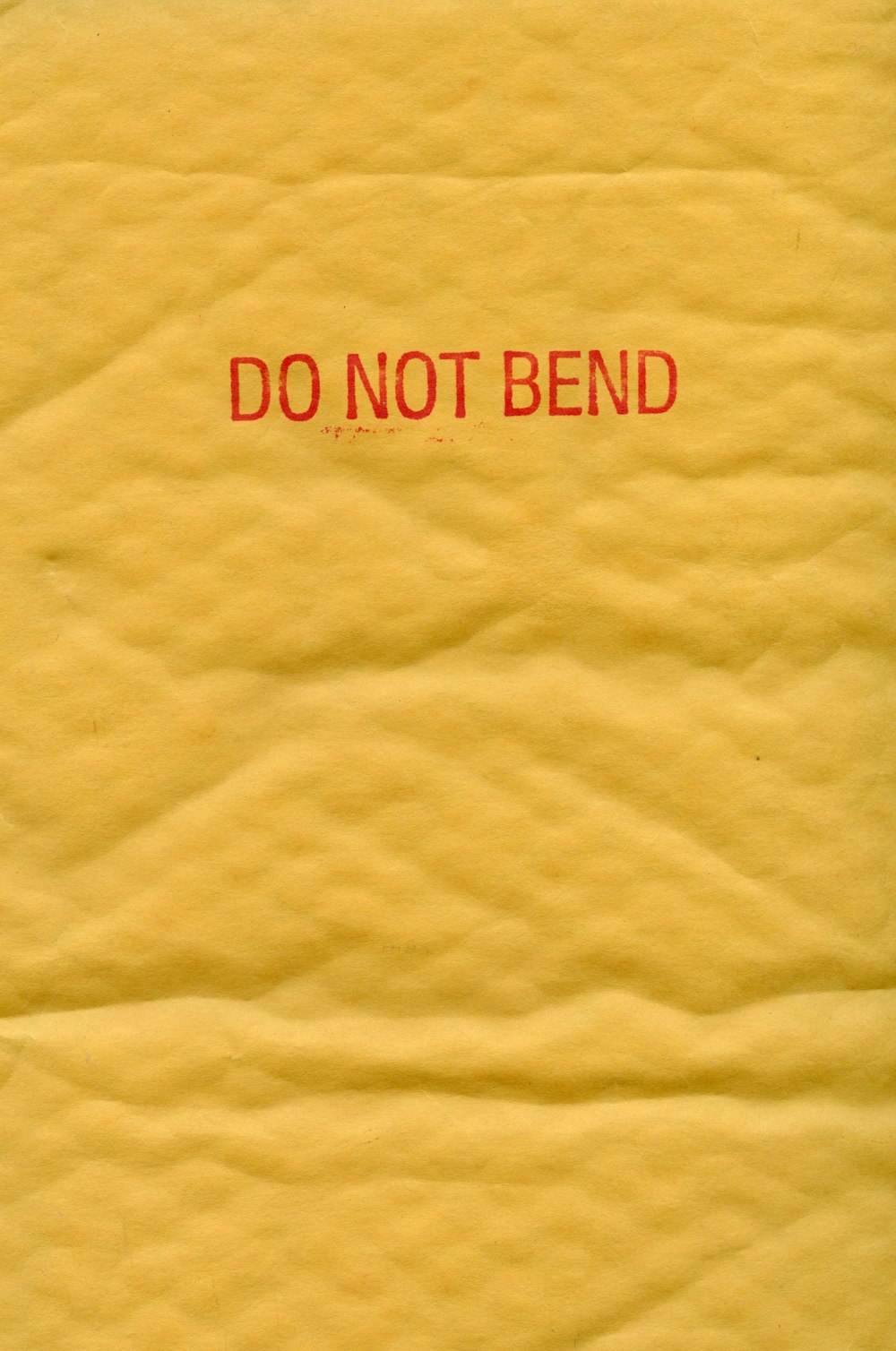 a piece of yellow paper with a red do not bend sign on it