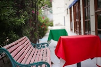 a wooden bench sitting next to a green table