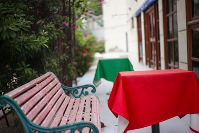 a wooden bench sitting next to a green table