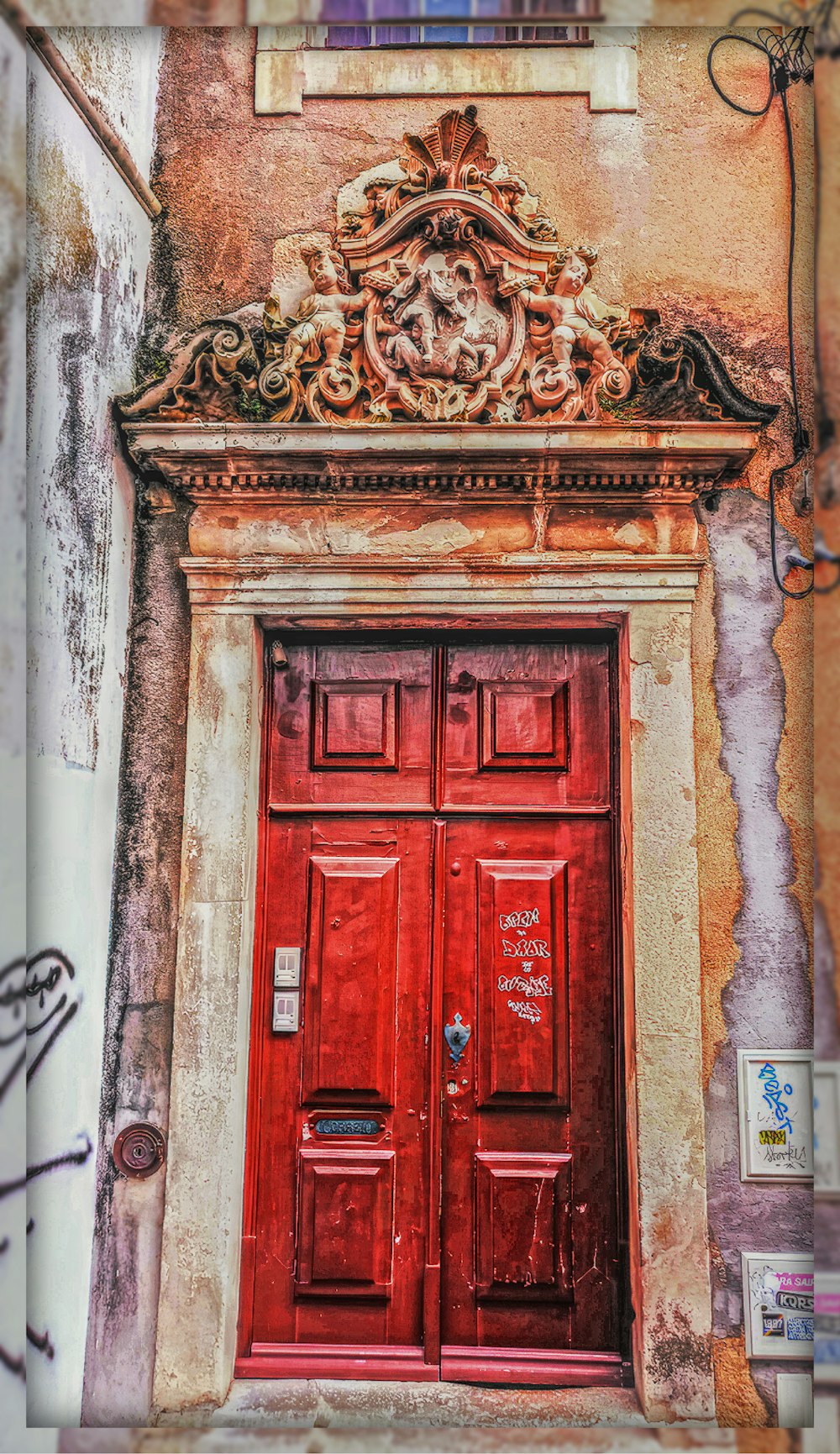 a red door with ornate carvings on the side of a building