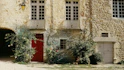 a red door in front of a stone building
