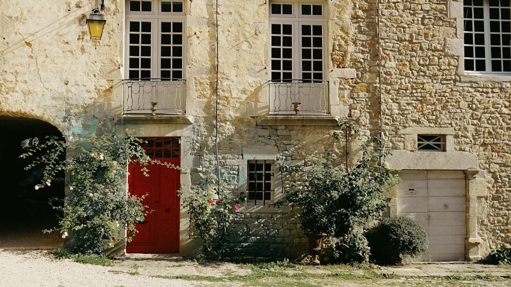 a red door in front of a stone building