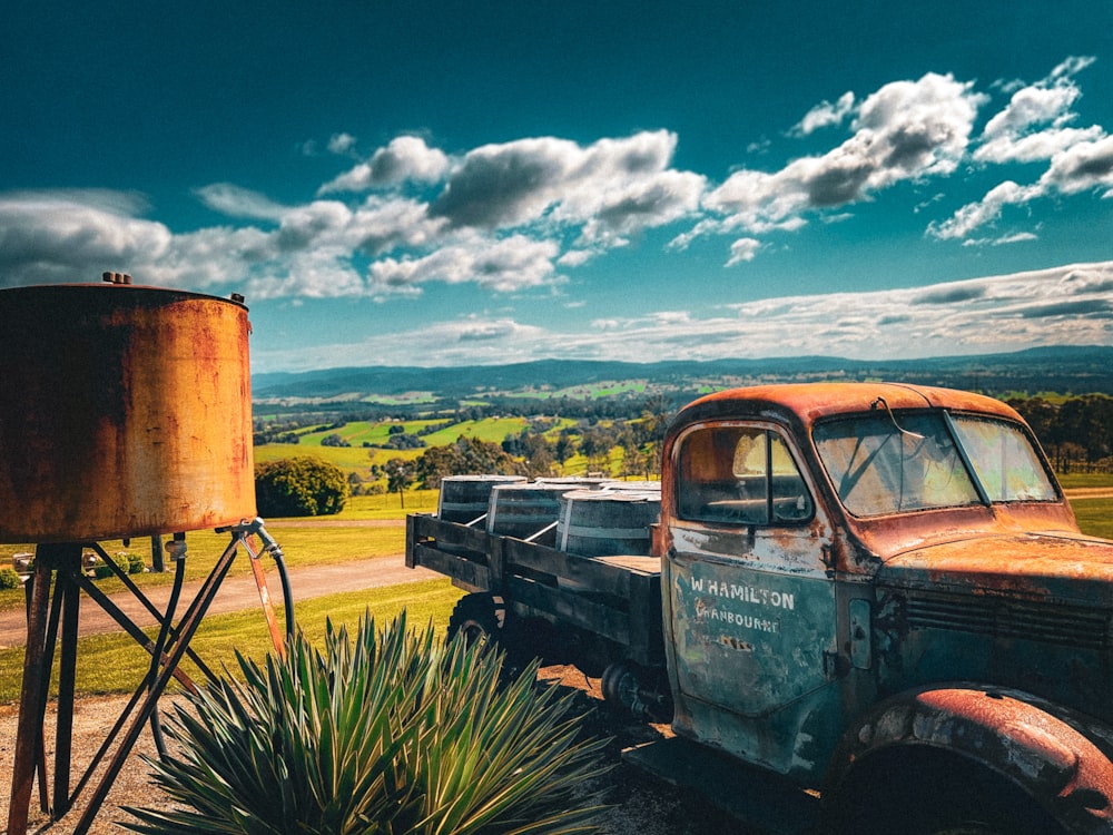 an old rusty truck parked in a field