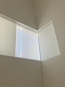Close-up of tempered glass panels with minimalist aluminum frames in a bright interior.