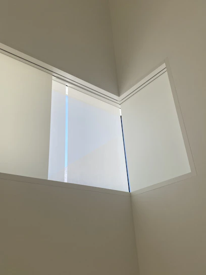 A close-up of a modern glass window installation reflecting a minimalist interior with natural light.