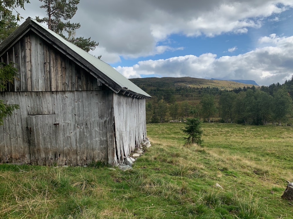 a barn in a field with mountains in the background