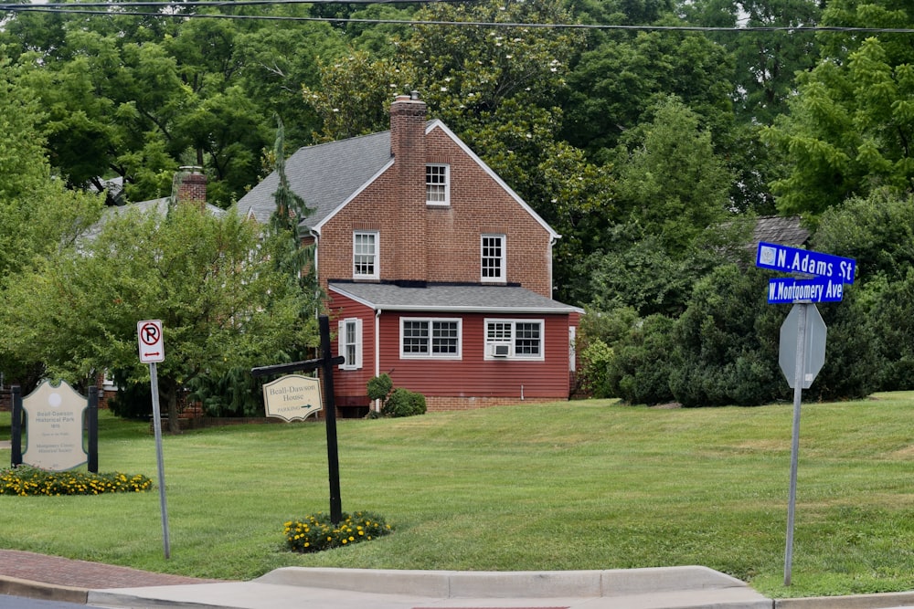 a red house with a blue street sign in front of it