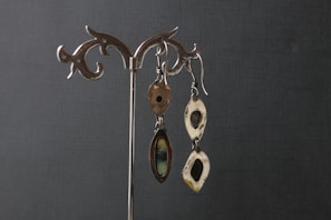 An assortment of silver earrings arranged artistically on a wooden surface.