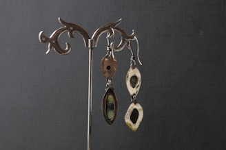 Shiny silver earrings displayed on a rustic wooden surface
