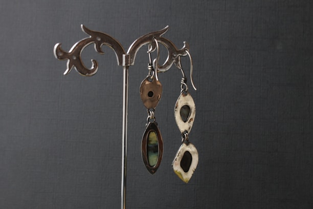 An elegant display of various sterling silver earrings arranged artistically on a soft fabric background.