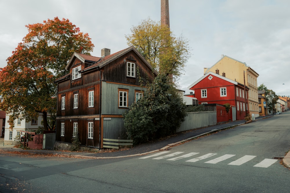 a red house on a street corner with a tower in the background