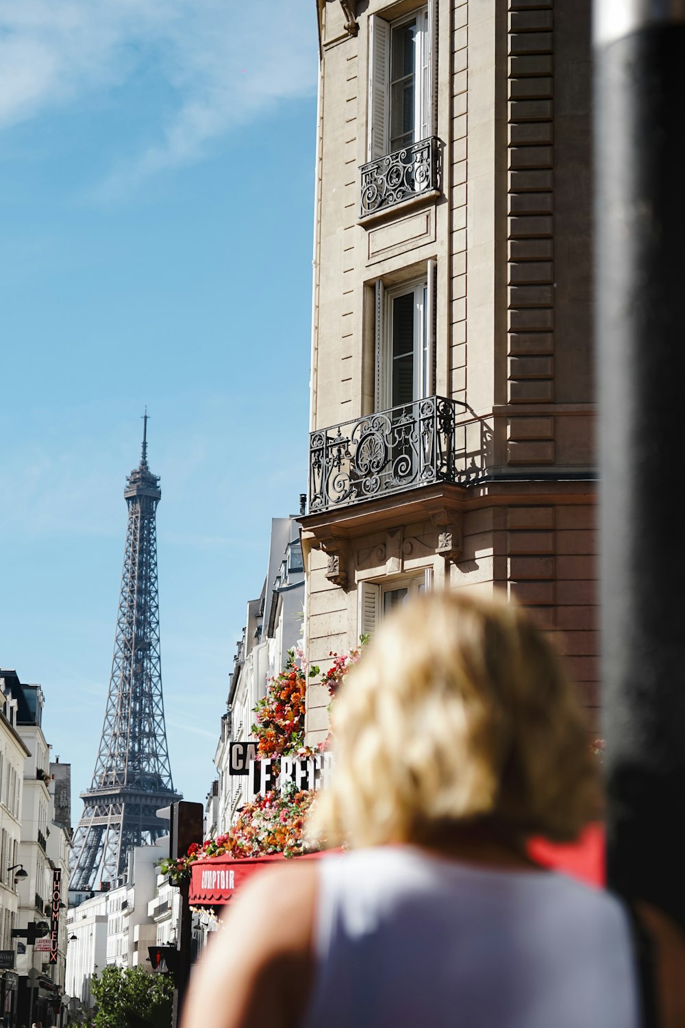 a woman is walking down the street in front of the eiffel tower
