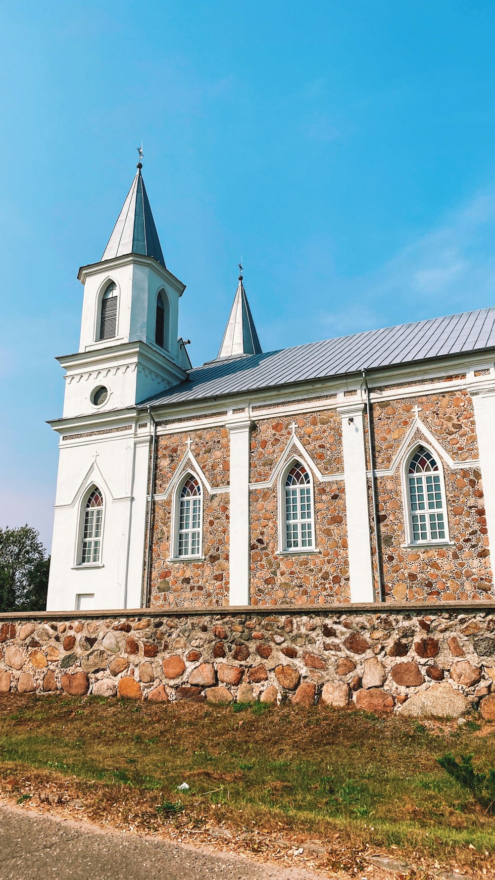 a stone church with a steeple and two windows