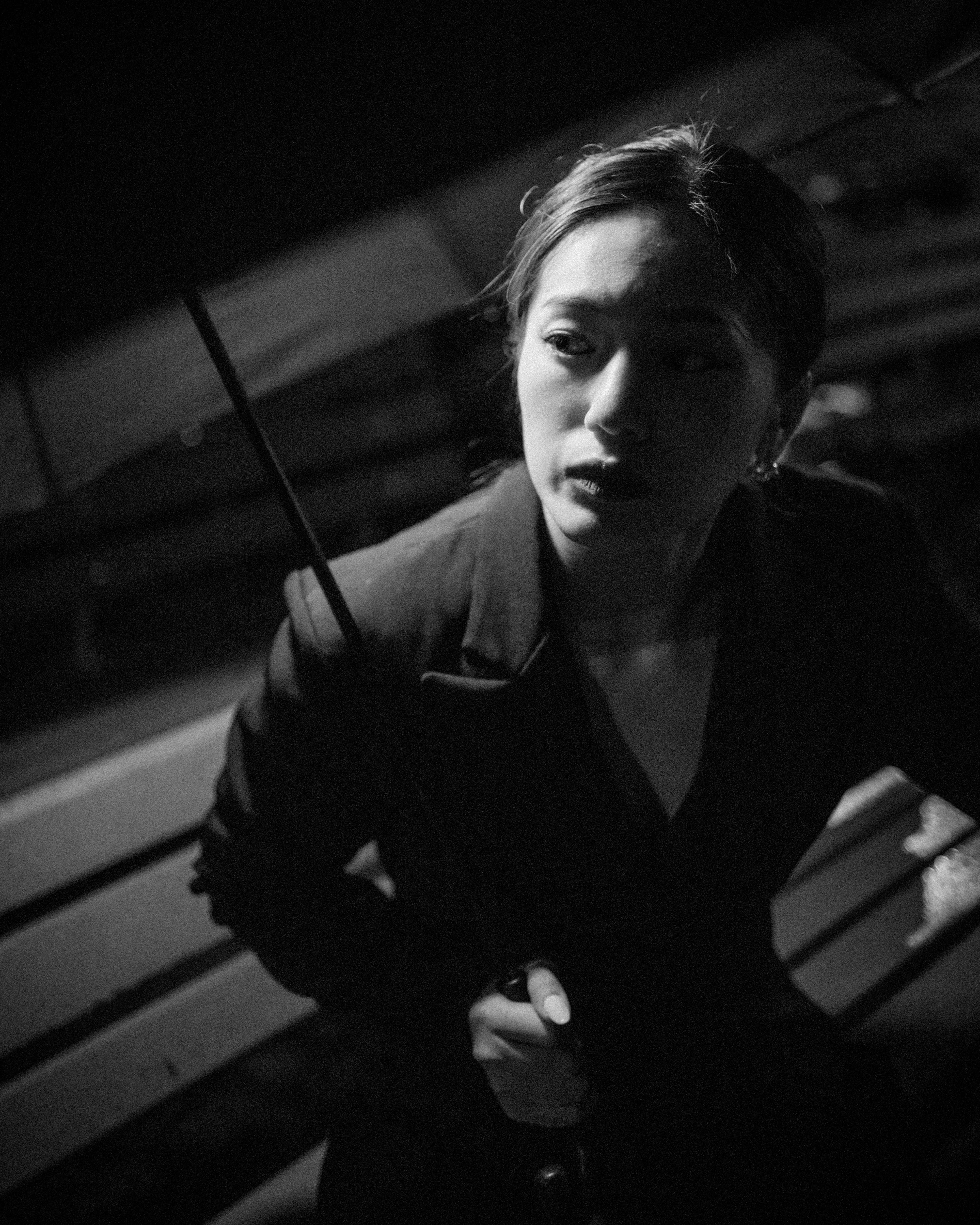 a woman sitting on a bench holding an umbrella