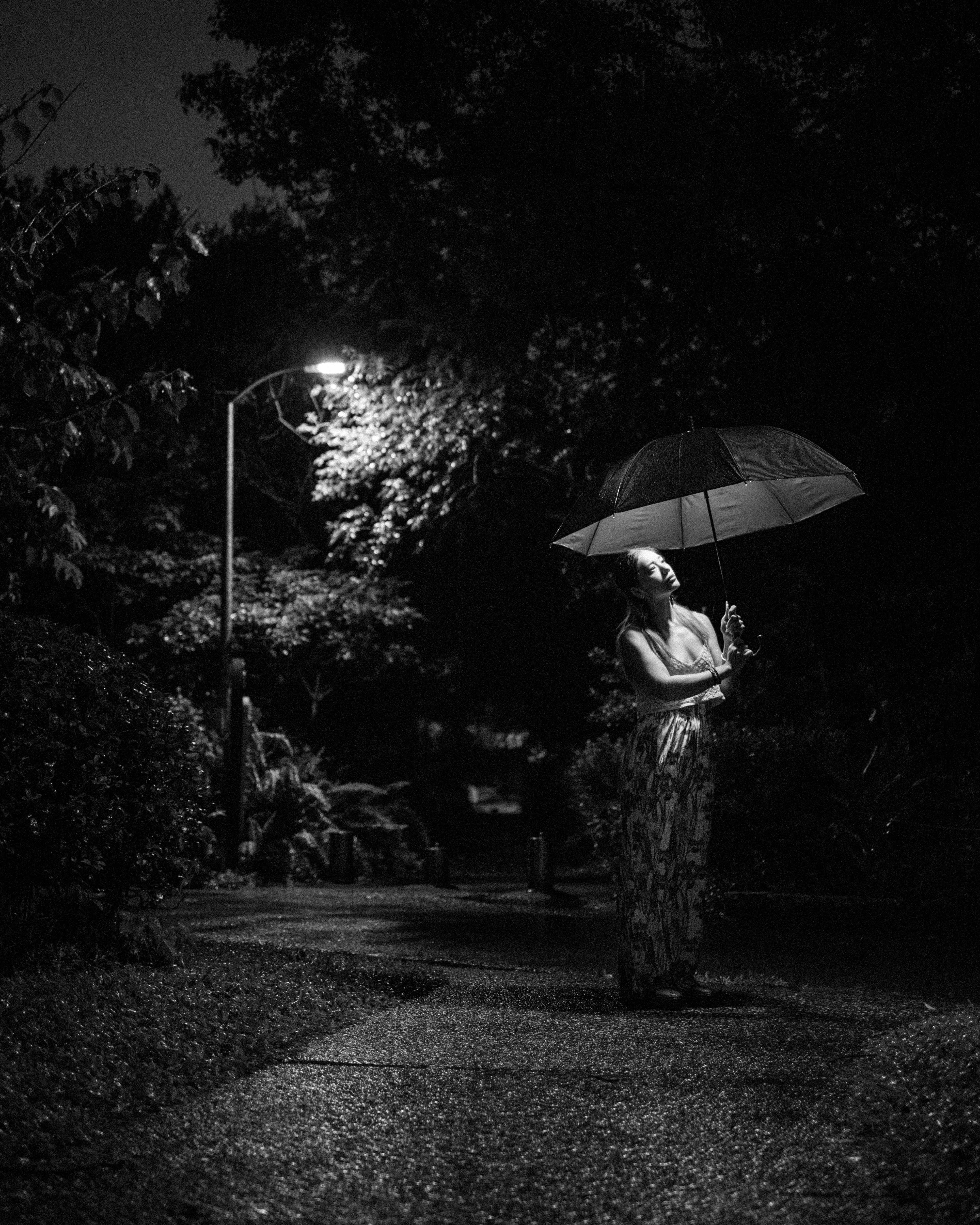 a woman holding an umbrella in the dark