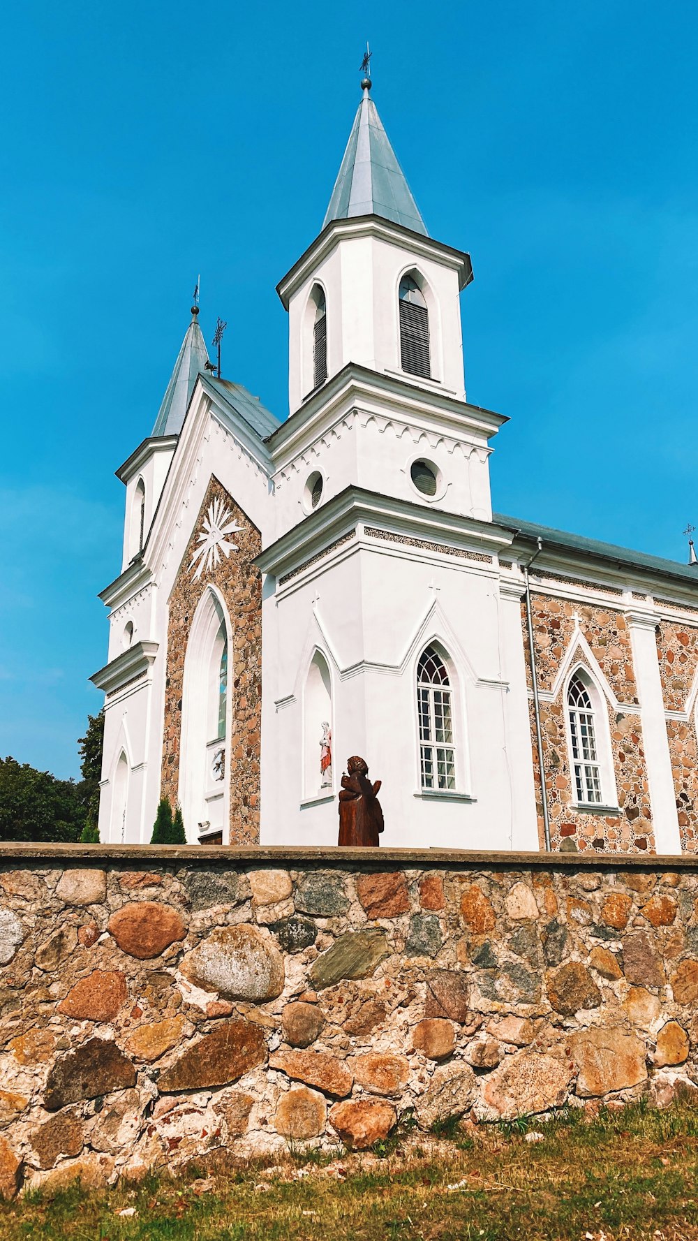 a person sitting on a stone wall in front of a church