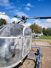 Technician inspecting helicopter rotor blades on a sunny day.