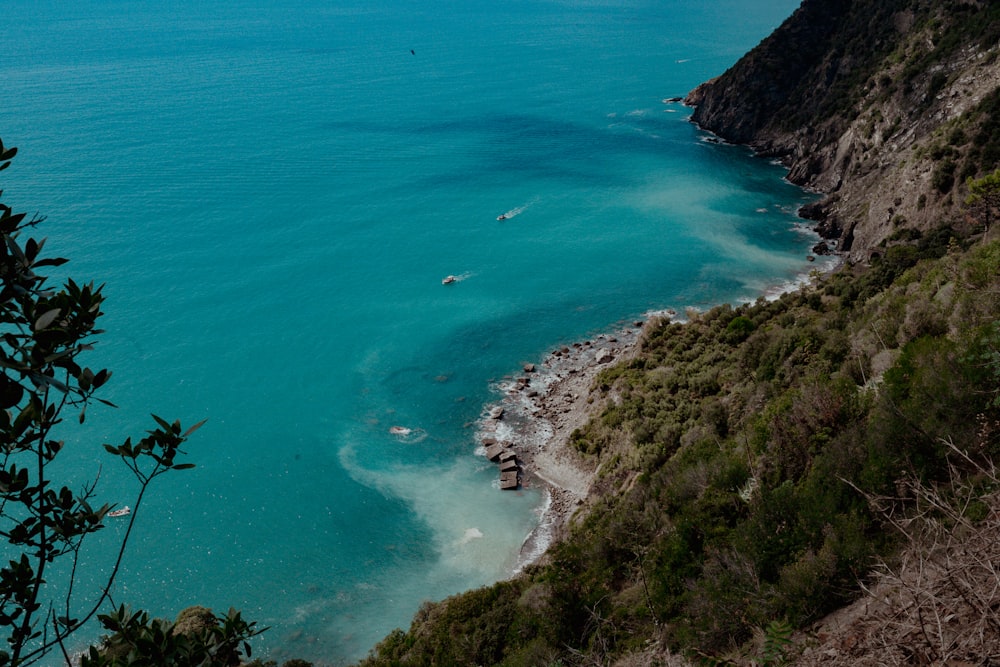 a body of water surrounded by a lush green hillside