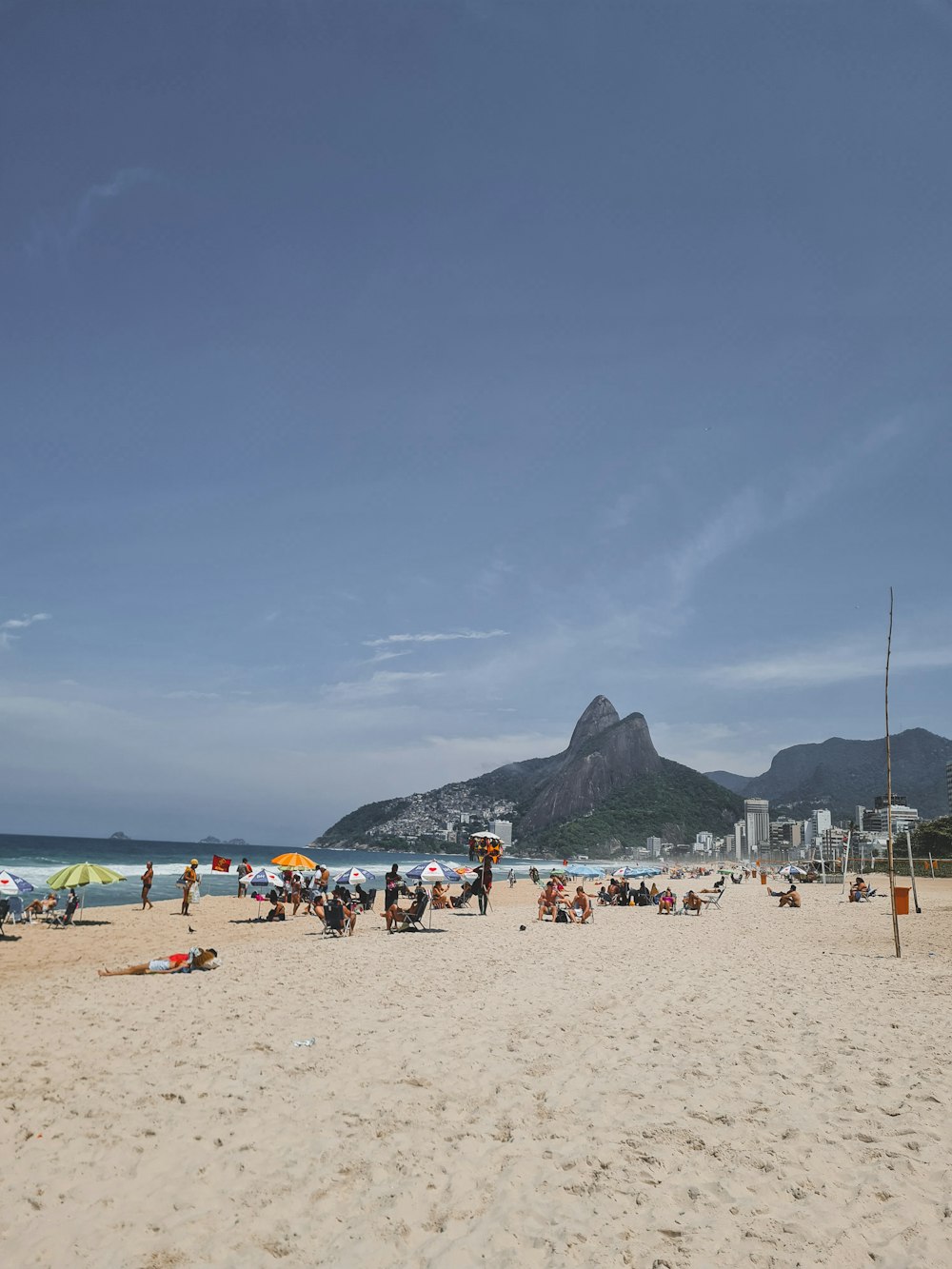 a group of people sitting on top of a sandy beach