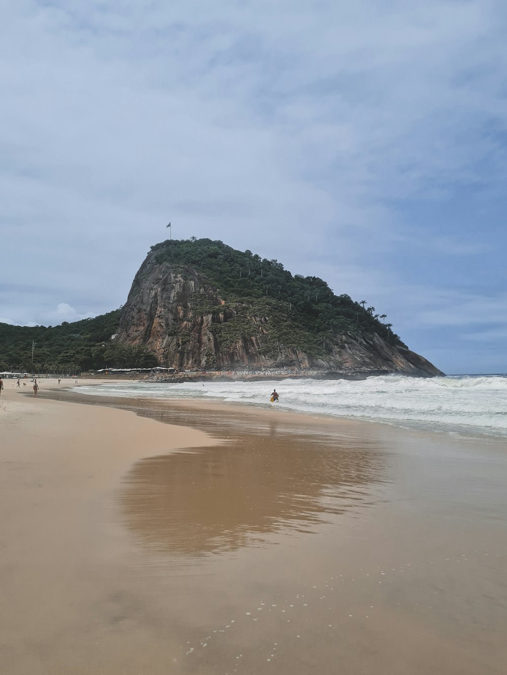 a sandy beach with a mountain in the background