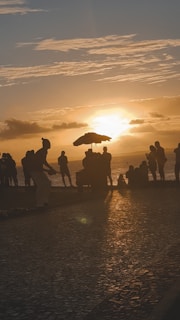 a group of people standing on top of a beach
