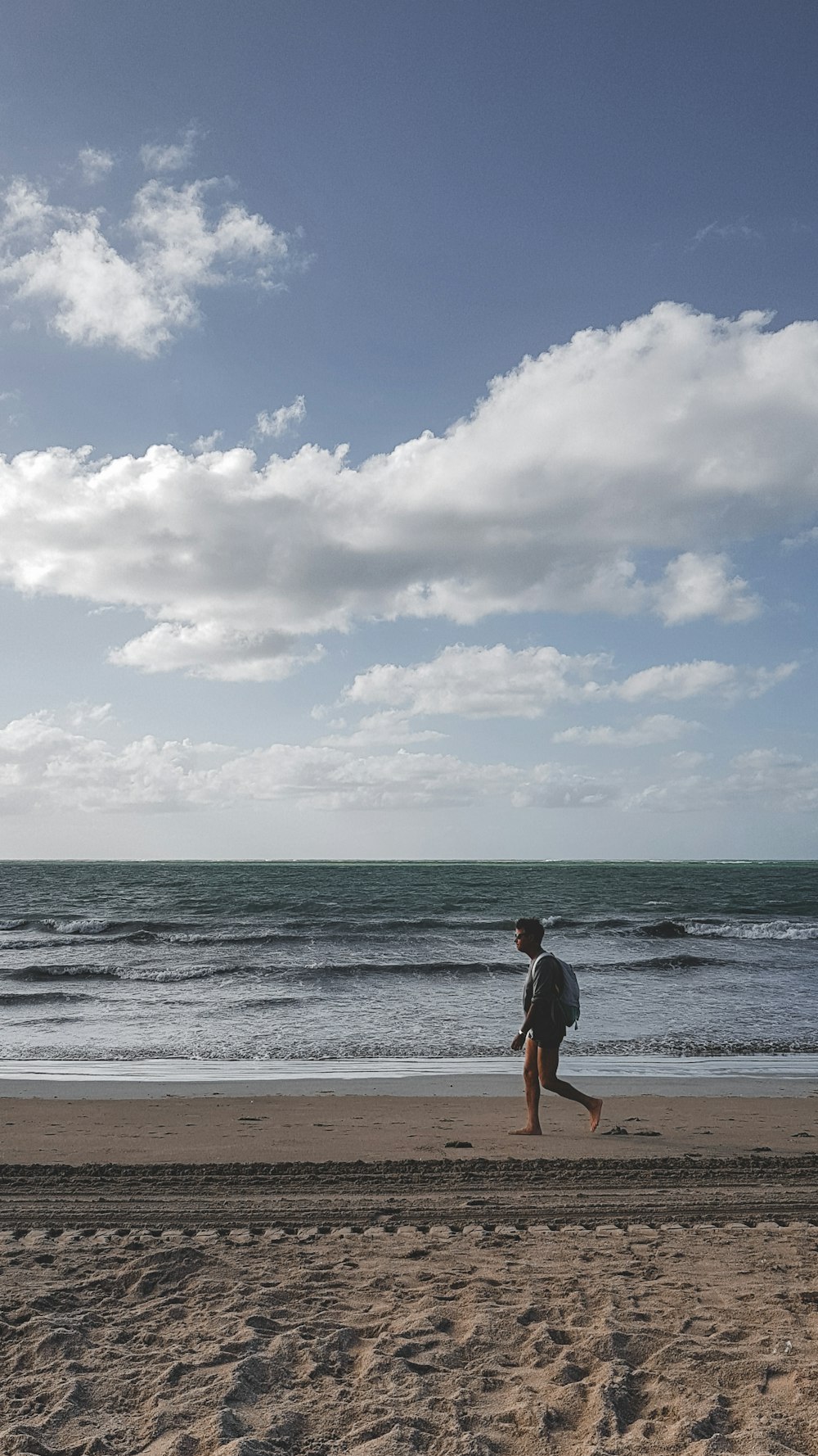 海の近くのビーチを走る男