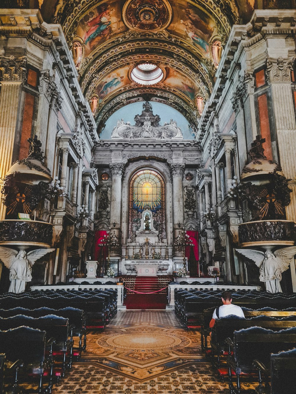 a man sitting in a church looking at the alter