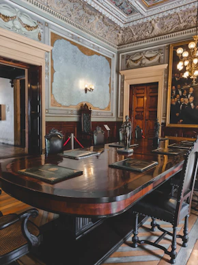 Historic diplomatic meeting room with vintage maps and documents on the table.