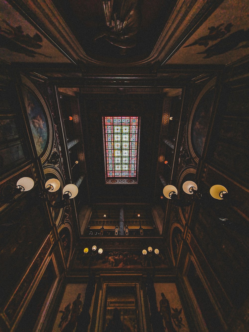 the ceiling of a building with a stained glass window