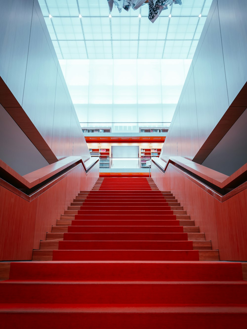 a red carpeted staircase leading up to a skylight