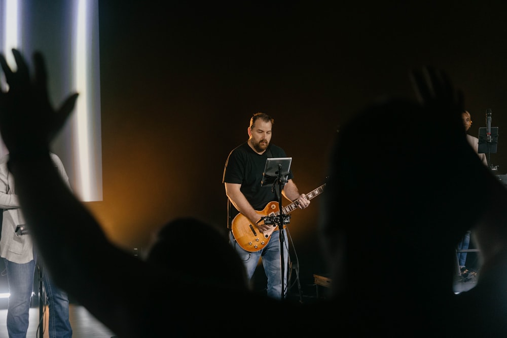 a man playing a guitar in front of a crowd