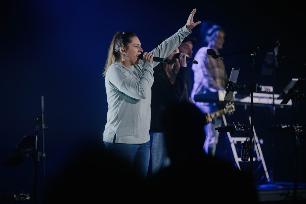 a woman singing into a microphone on stage