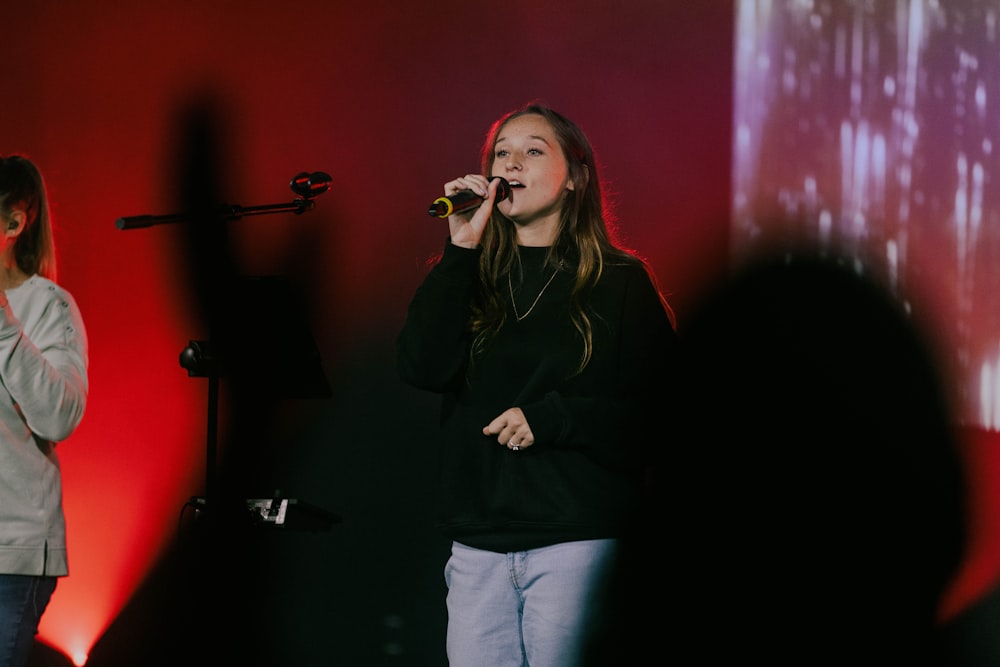 a woman standing in front of a microphone on a stage