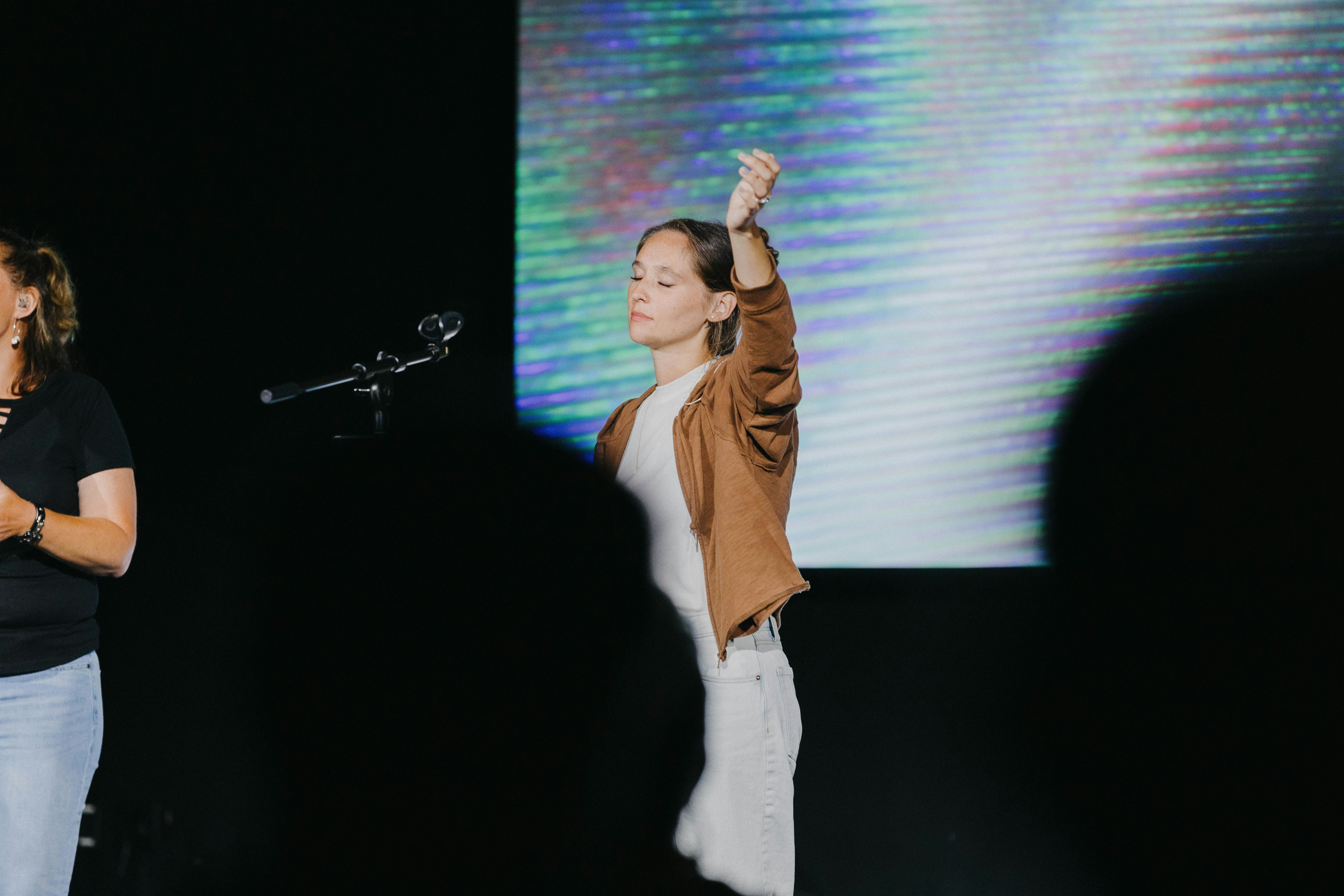 a woman standing next to a microphone on a stage